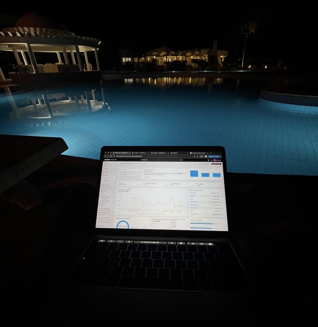 Hazem Telmoudi working on his Shopify store by the pool at night